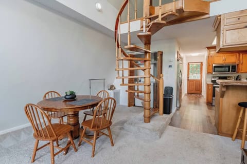 Kitchen table with 4 chairs and a view of the spiral stair case to the loft. Note the washer and dryer behind the spiral staircase.