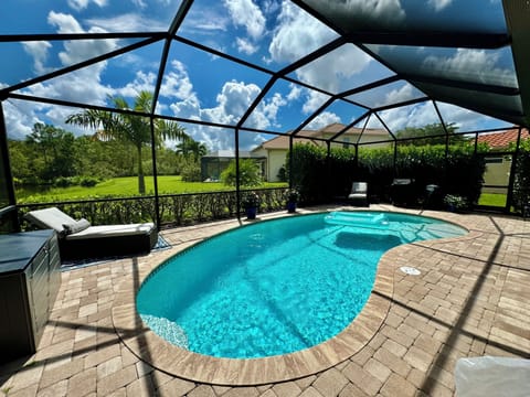 Screened Lanai with 2 loungers, BBQ, and  storage bin of pool toys and floaties.