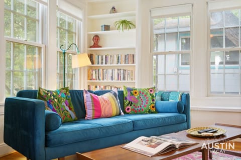 Colorful and bright living room with books, fireplace, smart tv and comfy seating!