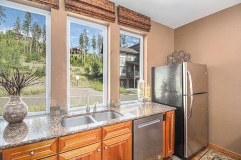 - Wash up while enjoying mountain views through three large picture windows
- Polished granite countertops and double basin sink offer everyday function
- Natural light and warm wood cabinetry give the kitchen an inviting glow