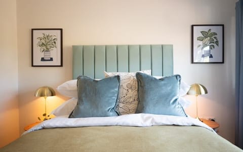 A cozy bed flanked by matching lamps and nightstands on either side, offering a symmetrical and inviting bedroom design.