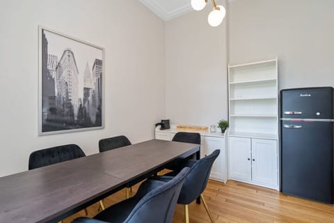 Chic dining room with ample seating and a vintage-style fridge, perfect for family dinners or entertaining guests.