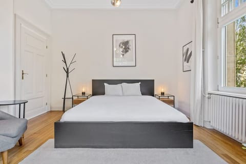 Relax in a cozy, light-filled bedroom with a plush double bed and serene decor, perfect for a restful night's sleep.