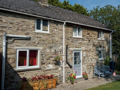 Rear view of Buttercup Cottage, wooden seats, planters, lawn