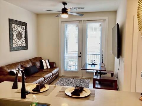 Living room with leather sofa, Smart TV and balcony 