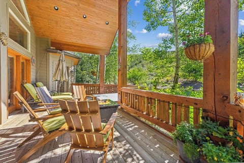 - Covered deck with Adirondack chairs and scenic views  
- Fire pit centerpiece for cozy evenings outdoors  
- Surrounded by trees, perfect for morning coffee or sunset