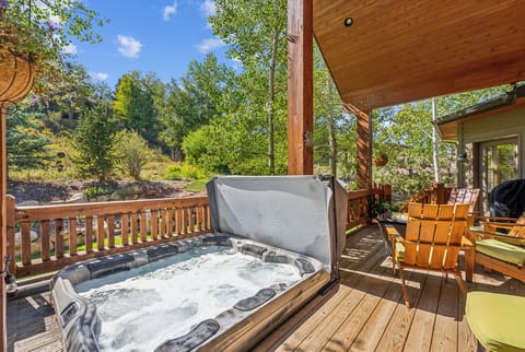 - Outdoor hot tub with bubbling jets set on a private wooden deck  
- Surrounded by tall trees and peaceful mountain nature views  
- Relax under open skies after a day of hiking or skiing