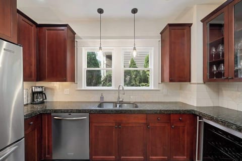 Modern kitchen with gas stove, ample prep space, and large fridge for all your cooking needs.