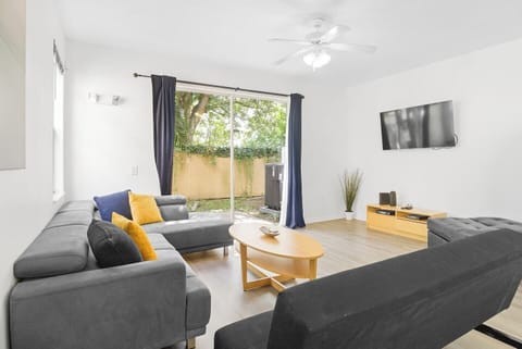 The living room offers a spacious and comfortable area for relaxation. It is equipped with a TV for your entertainment and features a large window, a ceiling fan that provides a pleasant breeze, and a coffee table that adds both functionality and a decorative touch to the space.
