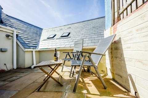 Outside garden with table, bottle of wine and chair.