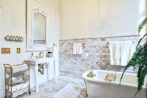 Marble tile, console sink, antique cast iron tub with brass fittings and fragrant bath salts with essential oils.