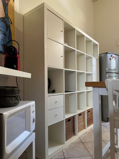 Parete attrezzata completa di piatti, bicchieri, tazzine, e attrezzi da cucina