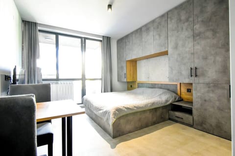 “Experience the perfect blend of modern industrial style and cozy comfort. Sleek concrete walls and warm wooden accents set the tone for a relaxing or productive stay.”