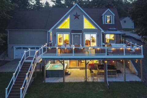 Experience the perfect evening ambiance with glowing lights, a spacious deck, and a hot tub retreat.