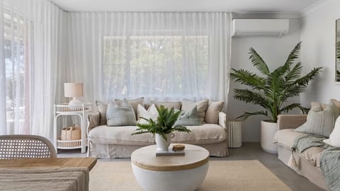 Relax in the light-filled living space, thoughtfully styled for comfort after a day by the beach.