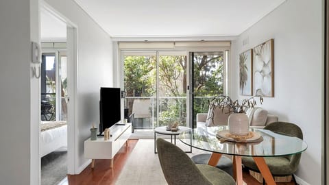 Sun-drenched and effortlessly stylish. Relax in a bright, open-plan apartment featuring warm timber floors, contemporary furniture, and seamless sliding doors that lead out to a lush, leafy outlook.