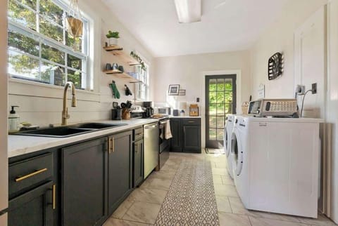 The kitchen equipped with a double sink, dishwasher, refrigerator, stove, and microwave for all your cooking needs. Plus, a convenient washer and dryer are available for your laundry needs during your stay