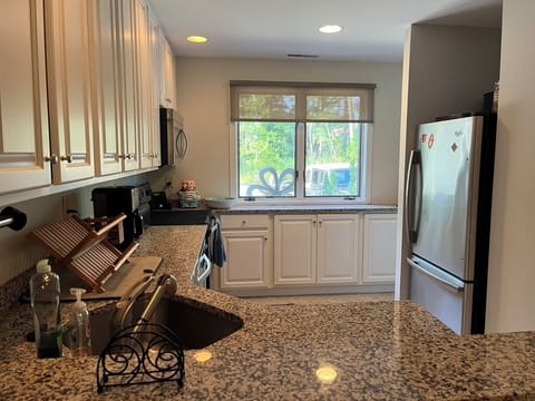 Kitchen with view of front window and refrigerator (has ice maker)