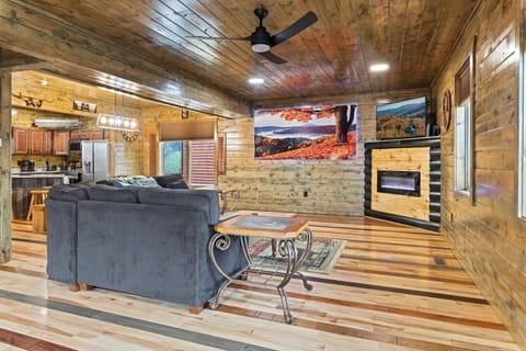 Living room with sectional sofa, Smart TV, and electric fireplace