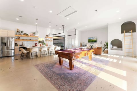 Open-concept space with billiards, full kitchen w bar seating, and unique built-in full bunks.