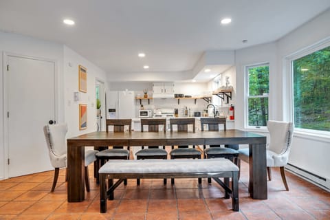An open-concept dining area bathed in natural light, surrounded by the beauty of nature. Perfect for a warm family dinner or a lively get-together.