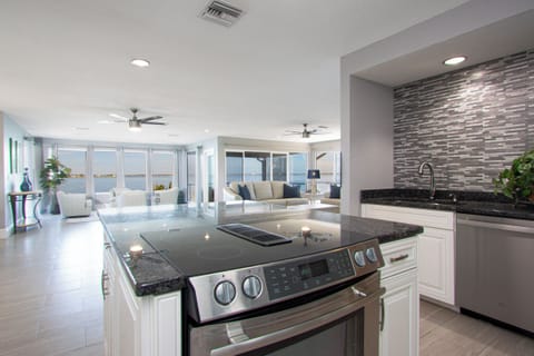 The kitchen, featuring high-end stainless steel appliances, opens seamlessly to the main living area, offering stunning river views as you prepare meals in style.