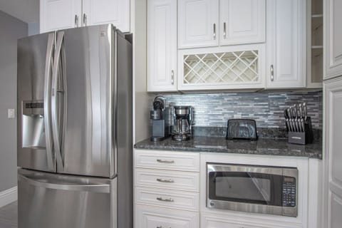 The kitchen features sleek white cabinetry, providing plenty of storage and a bright, functional space.