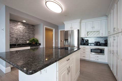 The kitchen boasts a central island, perfect for meal prep, complemented by an abundance of white cabinetry that provides both style and ample storage space.