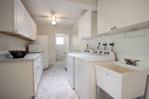 The laundry area is equipped with a full-size washer and dryer, along with plenty of cabinets for storage. A microwave and refrigerator are also included, adding extra convenience to your stay.