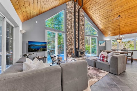 Living Room: Plush furnishings, 46” Smart TV, wood burning fireplace, open layout with dining and kitchen