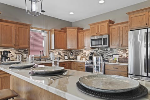 Fully stocked kitchen with barstool seating and a dining table that comfortably seats 6.