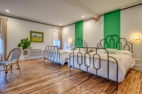 Suite 202 – The 2nd Floor Rattan & Stripes Suite boasts a pair of King Beds, Twin Day Bed, 2 Smart TVs, and En Suite Bathroom