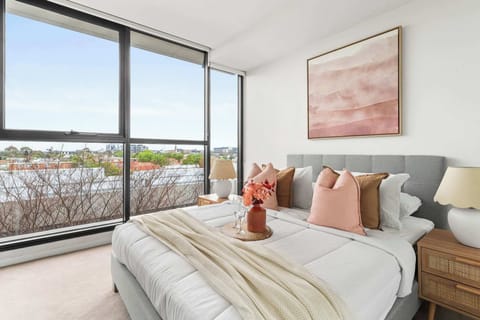 T master bedroom with a queen sized bed & plush pillows.