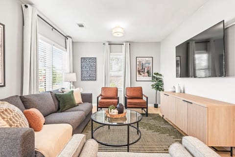 Relax in the spacious, beautifully designed living room with modern décor, a large Smart TV, and comfortable seating, perfect for unwinding after a day of exploring Atlanta.