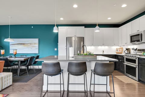 Large kitchen with working area and seating at the island that adds to the overall seating plan. An additional folding table with chairs and the island brings the total seating capacity to 15.