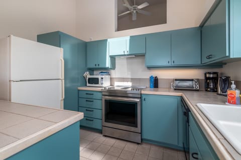 Kitchen with toaster oven, drip coffee pot, microwave, kettle and more