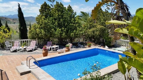 Sunbeds beside the pool with tables for cooling drinks. Plenty space to enjoy.