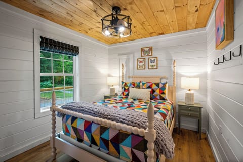 Primary bedroom has a queen bed, blackout shades and pops of color. 