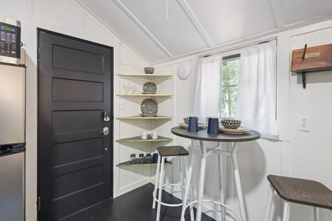 Small dining table with 2 chairs and loon themed dishes.