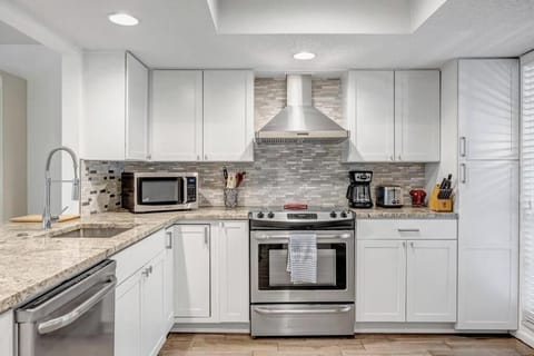 - Cook in style in this sleek kitchen with stainless steel appliances, granite counters, & a custom tile backsplash
- Equipped with microwave, coffee maker, and all the essentials
- Perfect setup for breakfast prep or dinner with the group