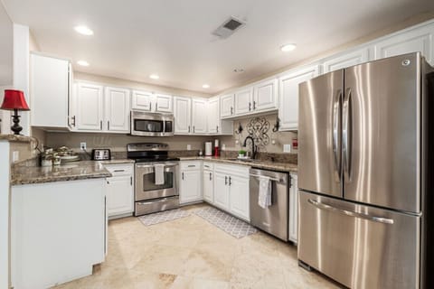 Fully stocked kitchen with stainless steel appliances.
