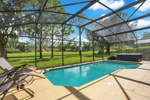 Relax by the screened pool with views of the lush green landscape.