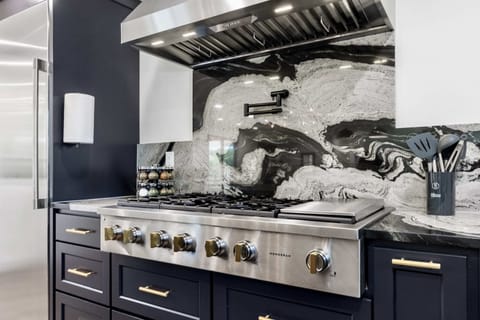 Cook like a chef in this modern kitchen equipped with top-of-the-line appliances and a stunning backsplash.