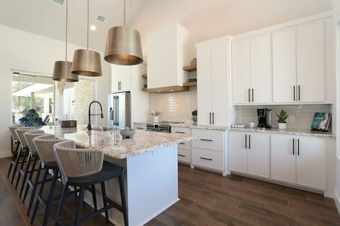 Modern kitchen with a large island, bar seating, and high-end stainless appliances.