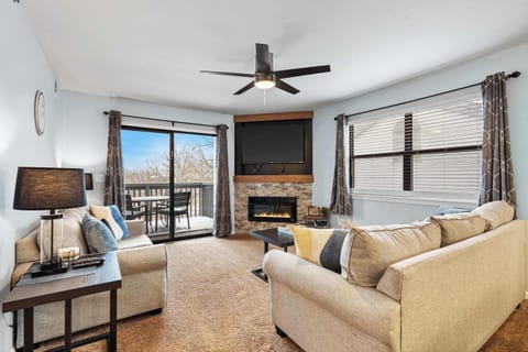 Open living room room with TV, and balcony access
