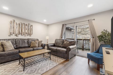 Open living space with TV, and balcony access (Unit #3)