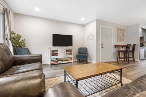 Open living space with TV, and balcony access (Unit #3)