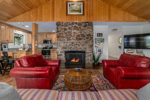 Relax in the open living area, complete with a cozy stone fireplace featuring gas logs. Enjoy meals in the dining space or at the kitchen bar with two seats, and unwind in the game area. The TV is equipped with streaming services.