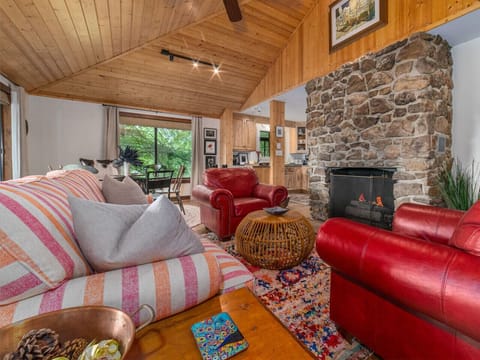Relax in the open living area, complete with a cozy stone fireplace featuring gas logs. Enjoy meals in the dining space or at the kitchen bar with two seats, and unwind in the game area. The TV is equipped with streaming services.