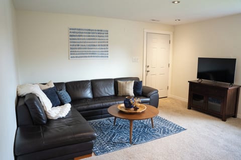 Bright and open, the living room features a large sectional and smart TV